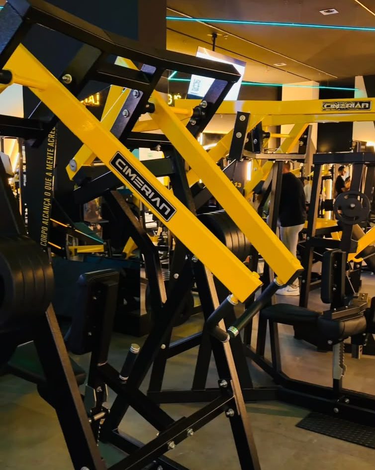 Máquinas de musculação amarelas e pretas no salão da Five Gym