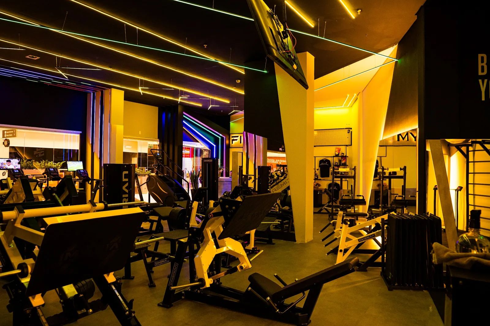 Salão de musculação da Five Gym com máquinas e luzes no teto